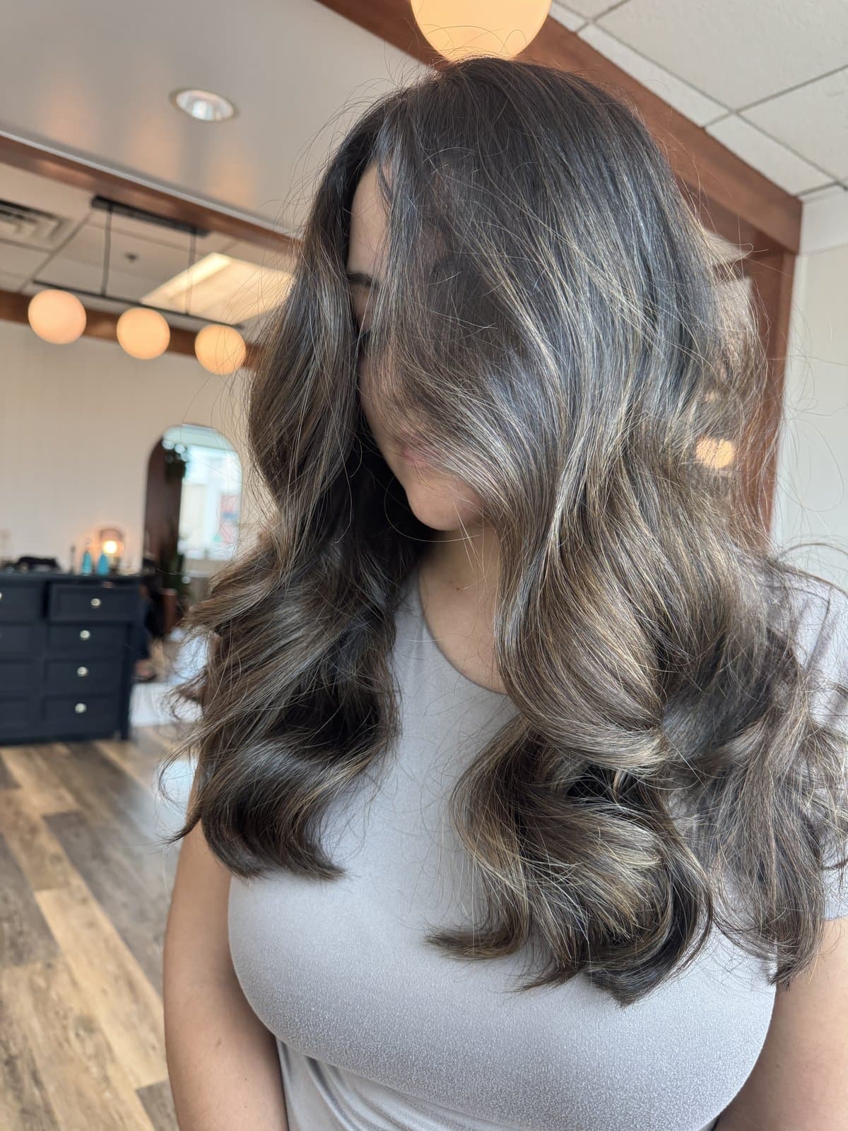 Dimensional brunette balayage with soft waves, styled in the salon