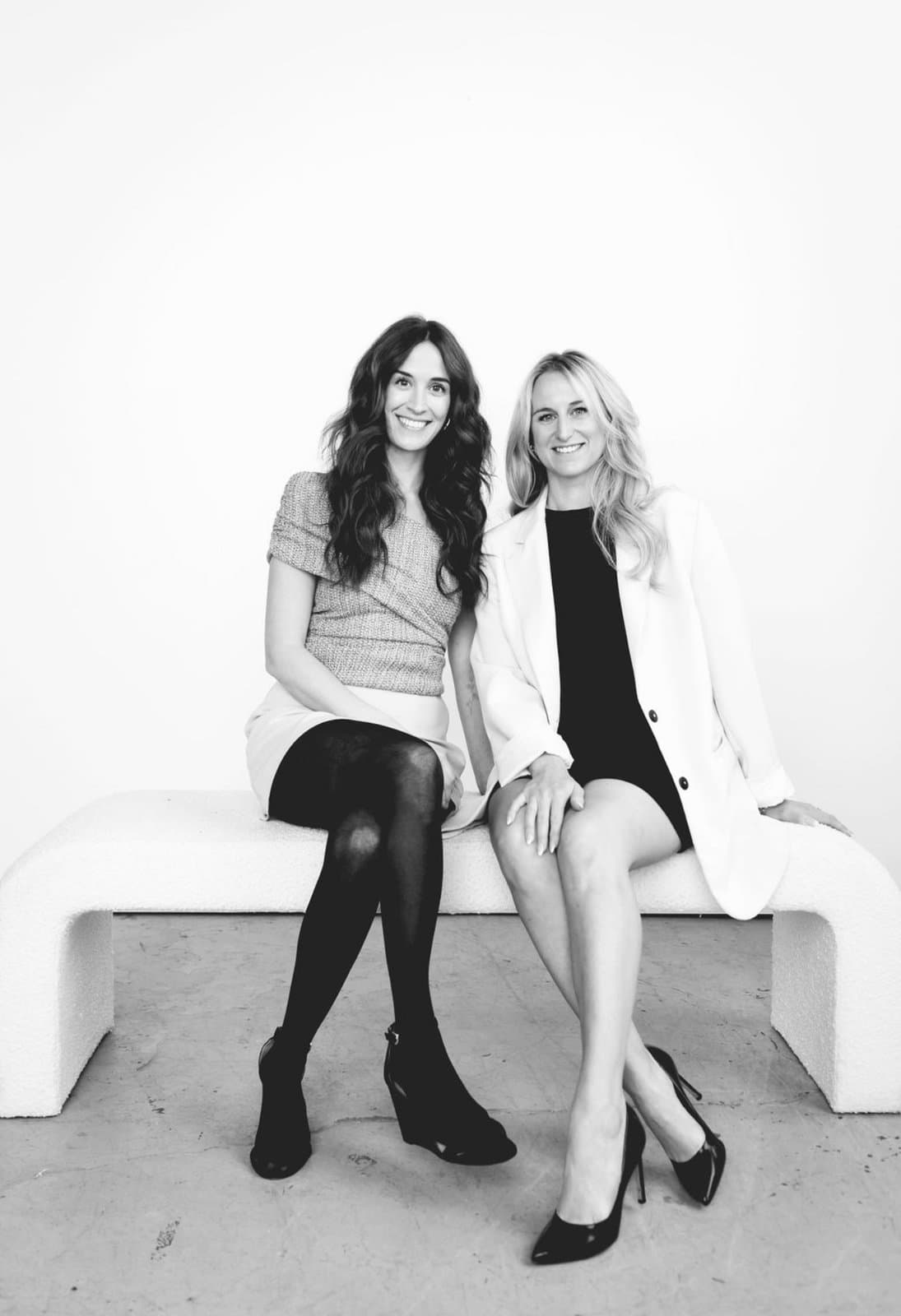 Samantha and Michaela seated together, black and white studio portrait