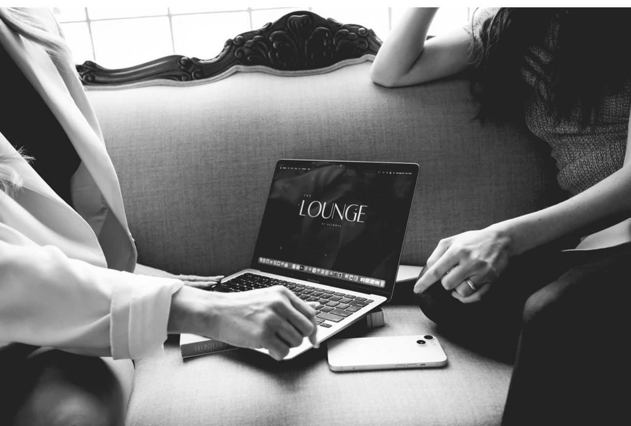 A laptop open to The Lounge wordmark while we work from the salon