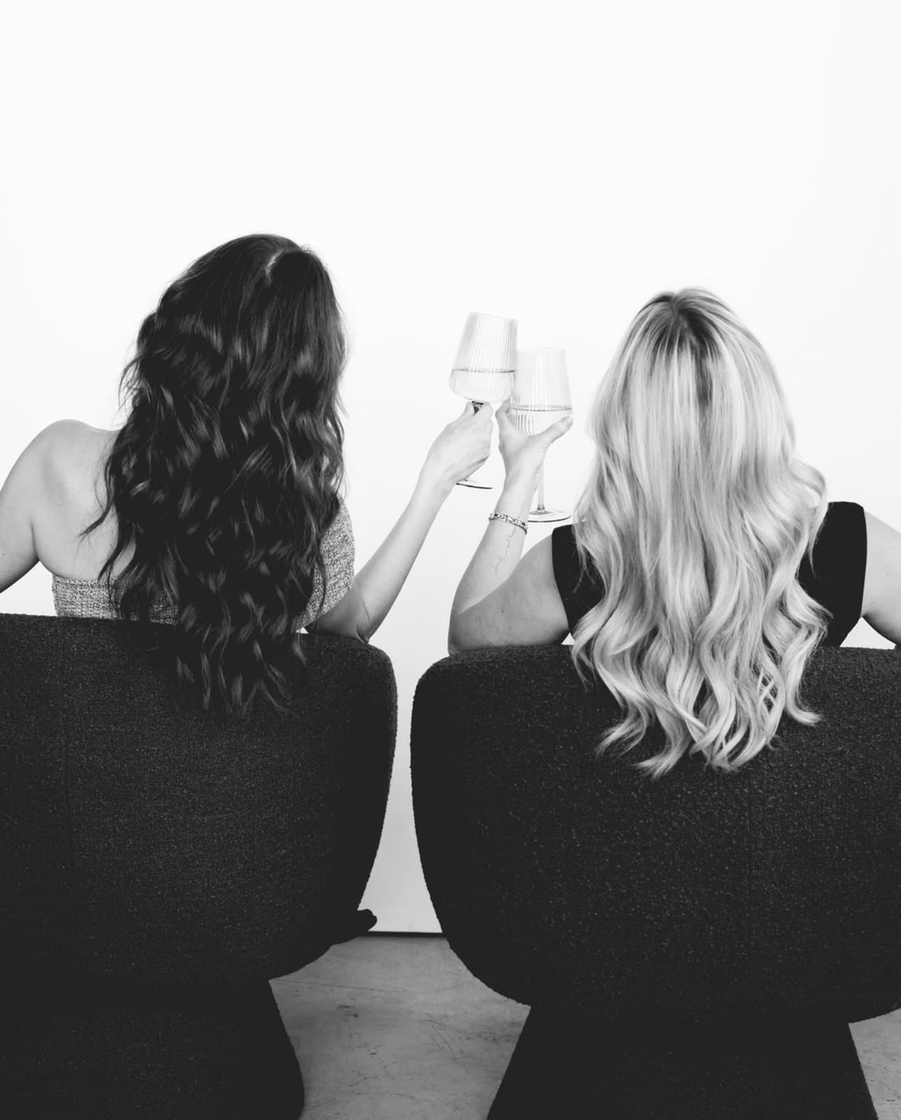 Samantha and Michaela toasting with wine glasses