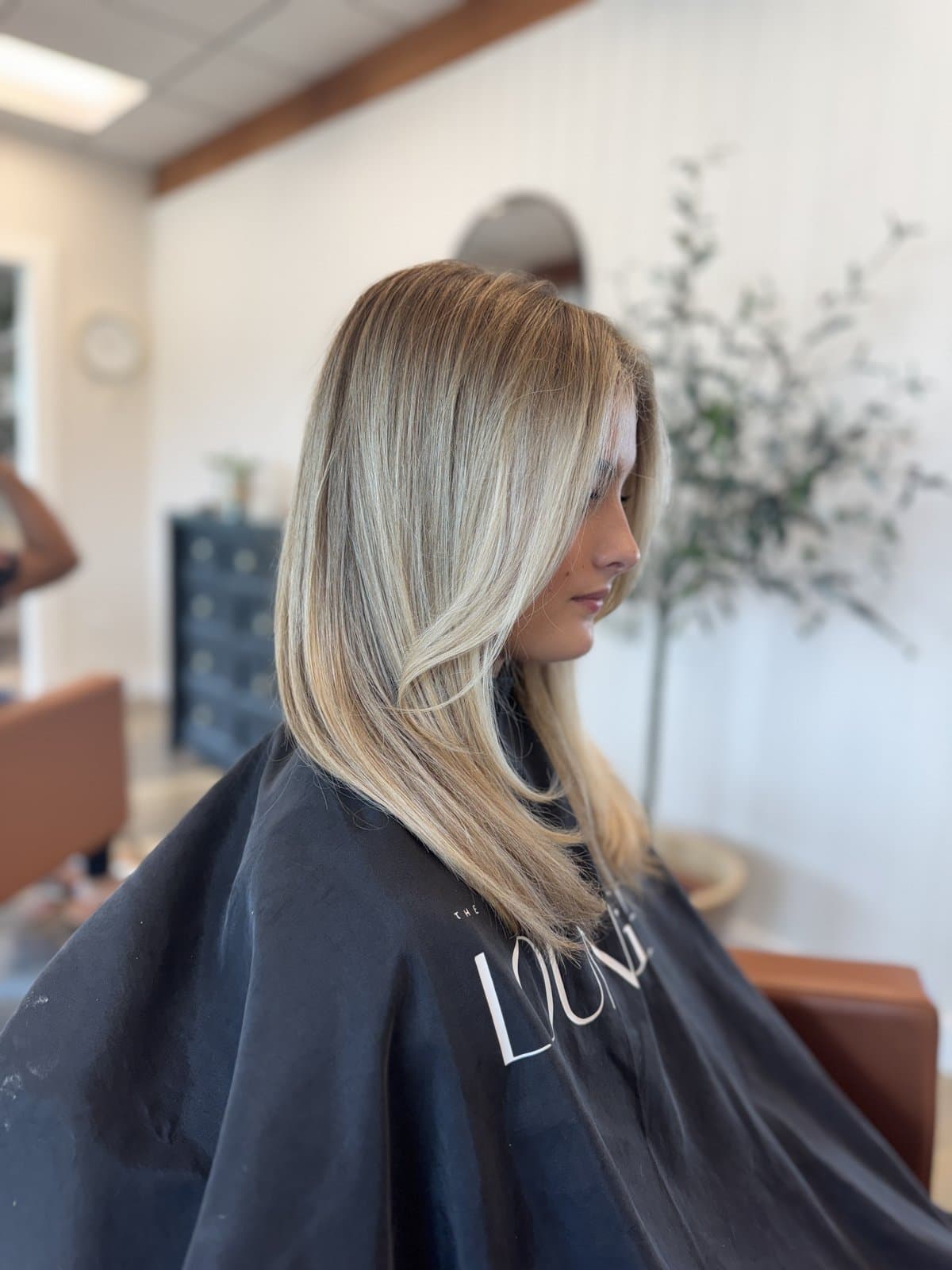 In-salon side profile of a finished cut and styled balayage